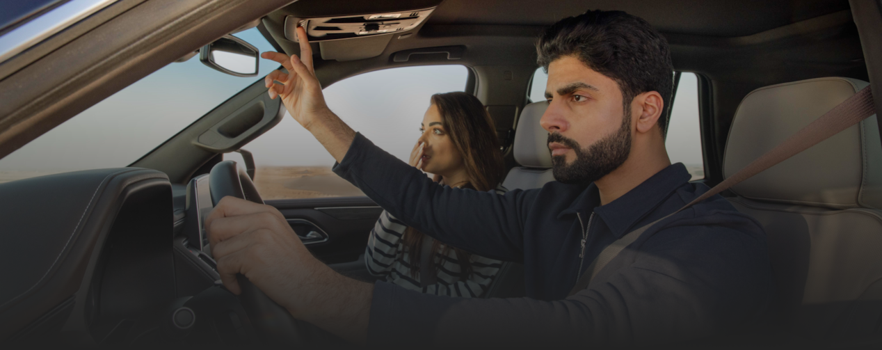 امرأة ورجل في المركبة وهو يضغط على زر أونستار