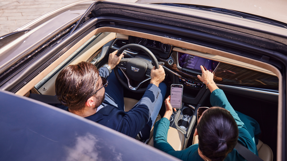 Woman pointing at the infotainment and man beside her